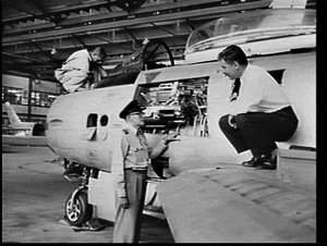 Mr. Howe and RAAF officer inspect the jet engine of an ...