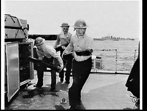 Sailors carrying Bofors anti-aircraft shells on HMAS Wa...