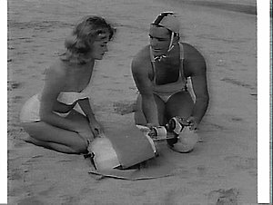Surf lifesaver and woman demonstrate mouth-to-mouth res...