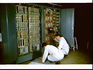 Electrical engineers work on an electrical switchboard,...