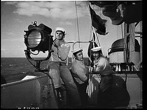 Sailors using a semaphore and signalling flags on the d...