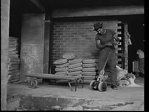 Builder's labourer using handcart to move loads