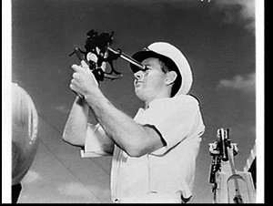 Officer using a sextant on HMAS Anzac at sea en route f...