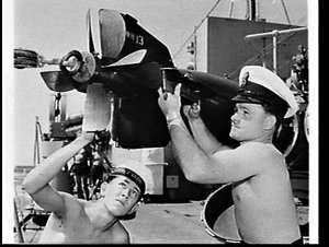 Petty officer and sailor working on a torpedo on HMAS A...