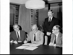 Dalgety signs a document at the Primary Industry Bank, ...
