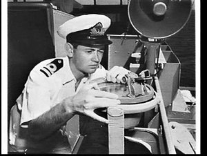 Officer using a compass on HMAS Anzac at sea en route f...