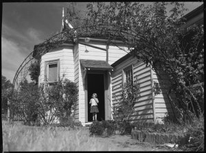 File 06: Weathboard house with little girl in doorway, ...