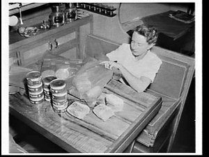 Mrs. Len Staples on their yacht Solquest sorting grocer...