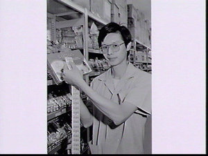 Storeman with bar code labels for a tin of confectioner...