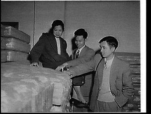 Asian students inspecting mattresses at a bedding facto...