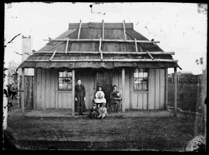 Women and children in front of bark roof house, Gulgong