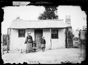 Woman and two daughters with house, Hill End
