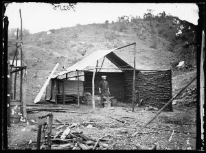 Blacksmith working on anvil in shed in the goldfields, ...