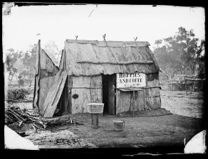 Bark hut with sign "Hot pies and coffe (sic), always re...