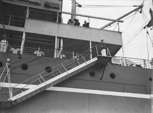 Passengers watch as the ship's gangway is lowered