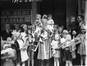 Santa Claus holding children at Unity Hall, Paddington