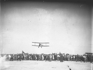 A Gypsy Moth flying low over the heads of spectators
