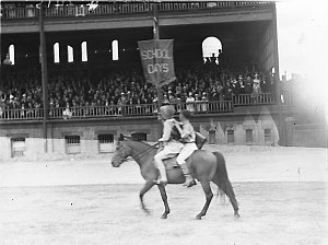 A girl and boy parade their pony around the ring.  "Sch...