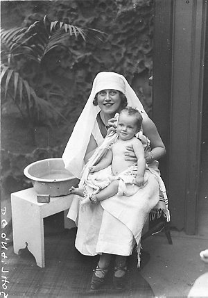 Musical comedy star Dorothy Brunton washing a baby