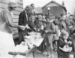 Schoolchildren line up for free issue of soup and a sli...