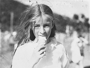 A close-up of a girl eating ice-cream at the butchers' ...