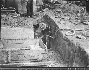 Workman using a jack-hammer at a city excavation