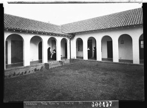 Arched colonnade and courtyard with two nuns, Catholic ...