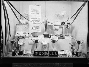 McDowells' window display of silver cups and trophies f...