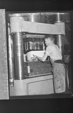 Factory worker takes a bakelite radio casing from Nally...