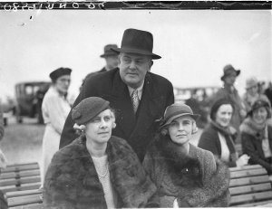 A man and two women society spectators