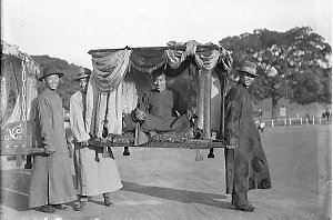 Two unidentified Chinese dignitaries being carried in s...