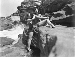 Two Capitol Theatre chorus girls in swimsuits, one comb...