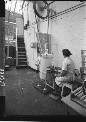 A woman operating a rubber moulding machine