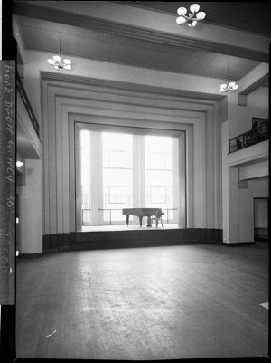 Interior of a hall, showing a small stage with a grand ...