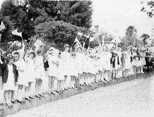 Schoolgirls wave their flags at the Duke