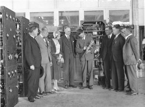 Chief engineer shows visitors a transmitting valve.  Si...