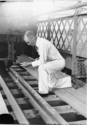 Railway engineer taking measurements of surfaces of tra...