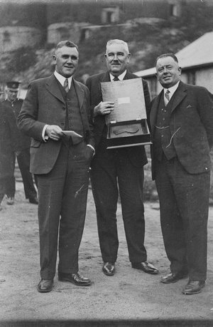 Officials with presentation plaque, a map of Australia ...