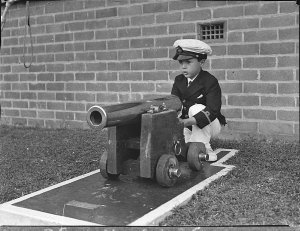 Young Boris Neville plays with the cannon in front of t...