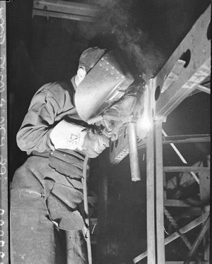 A welder at work building double-decker bus bodies