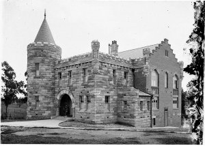 Building with archway round tower and Scottish pipers [...