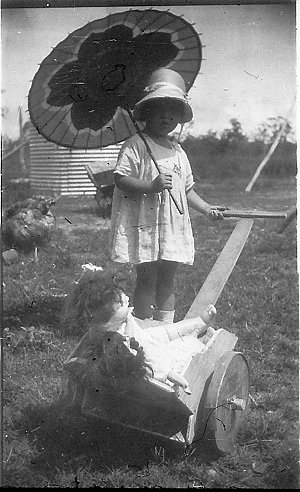 Little girl with doll cart made by her father, Robert P...