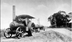 Steam traction engine hauling log, river end of Cameron...