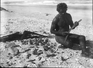 Aboriginal man on beach making boomerang - Port Macquarie area, NSW