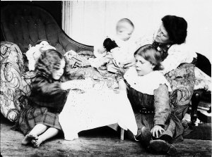 Mother with children. Girls playing with tea set - Scon...