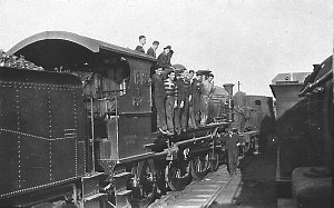 "Our mob on engine [no. 1318], foreman standing by pist...