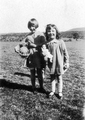 Two children playing with dolls. A rag doll came free w...