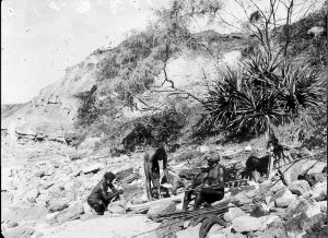 Three Aboriginal men on beach making tools & weapons - Port Macquarie area, NSW