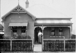 7 Dalley Street. Woman and dog on verandah of house - Q...
