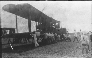 Local people help to manhandle the plane into position ...
